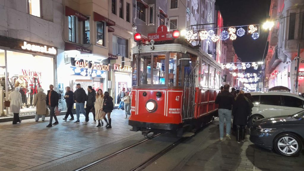 Istanbul's nostalgic tram glides through Istiklal Avenue on a lively January night