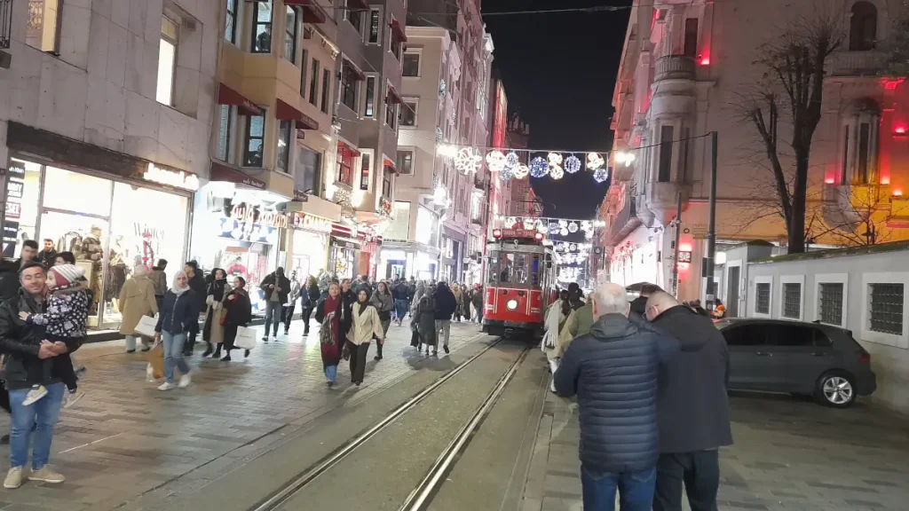Istanbul's nostalgic tram glides through Istiklal Avenue on a lively January night